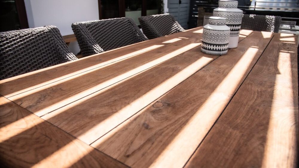 louvers shade on a beautiful wood table - Azenco Outdoor pergola