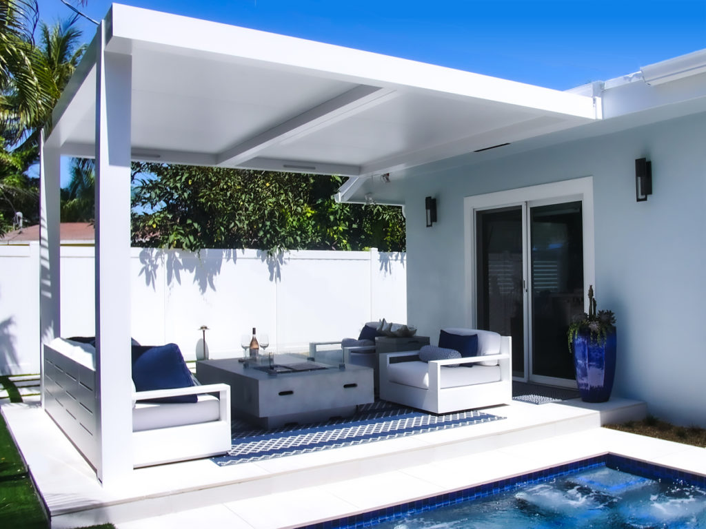 outdoor living room covered by pergola with fixed roof - hurricane zone