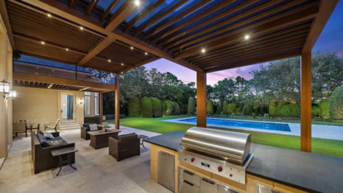 Luxury covered outdoor kitchen with louvered roof - modern pergola design