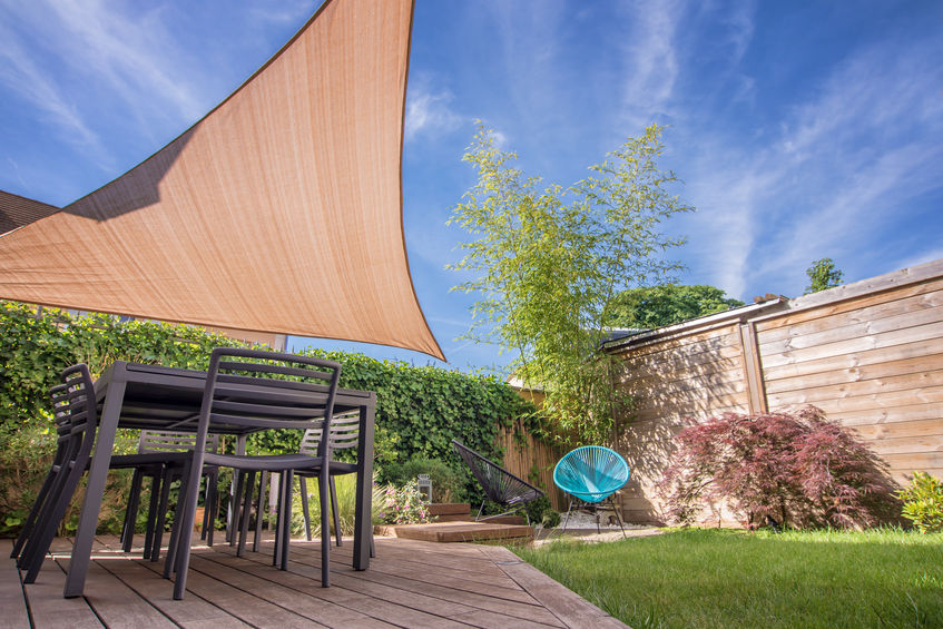 Patio covers: Wood terrace covered by a shade sail