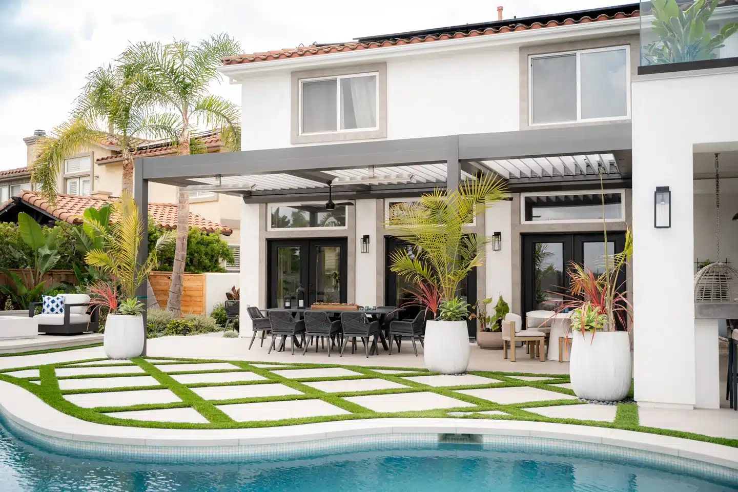 Modern patio with pergola, outdoor dining area, and pool