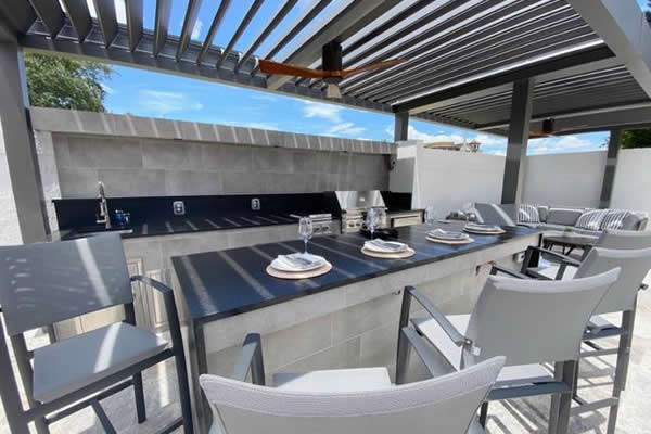 patio enclosure: outdoor kitchen covered with louvered pergola in aluminum