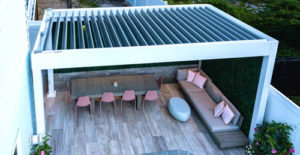 white pergola on a deck with louvered roof