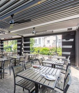 Increase capacity of Southern Kitchen Table in New York with a covered outdoor terrace equipped with r-blade louvered pergoal by Azenco Outdoor