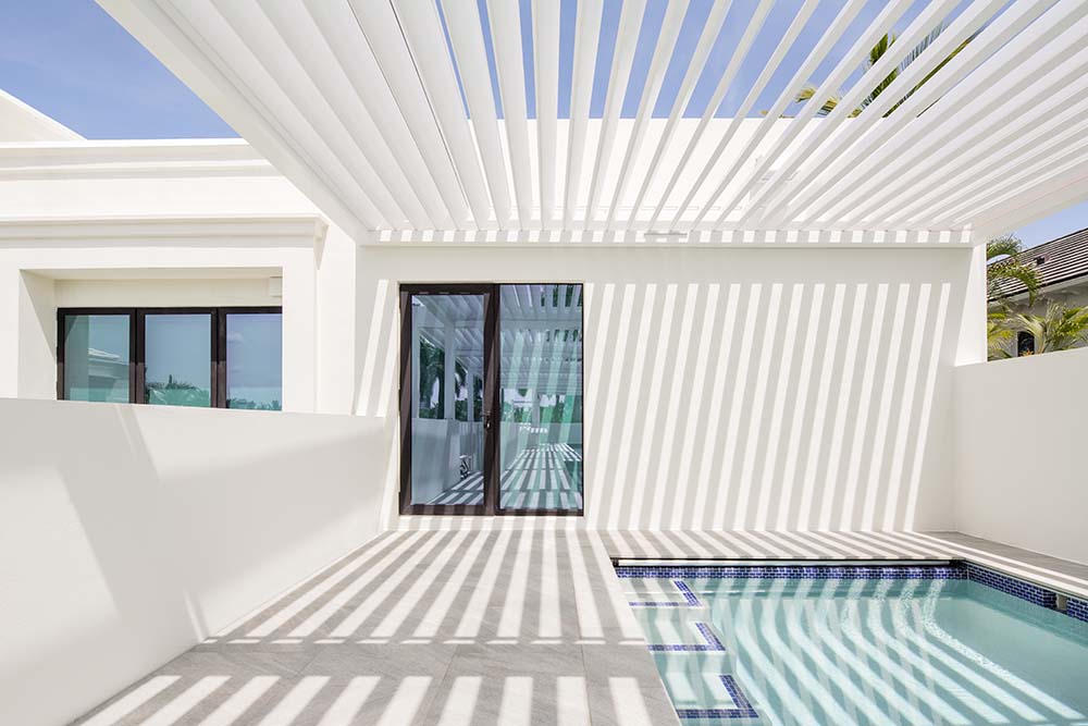 Azenco’s advanced color matching capabilities to select an exterior powder coating: the exact alabaster white as the home. Pergola R-Blade with louvered roof.