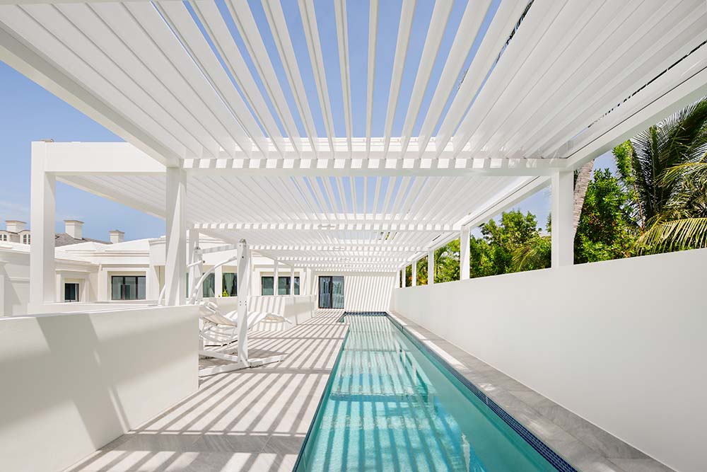 R-Blade pergola by Azenco: Featuring seven independently-controlled pergola roof zones, to manage the amount of shade, or open completely for full sun on the pool deck.