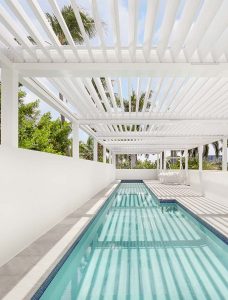 R-Blade louvered pergola over a rooftop pool. Risers, dual-walled louvers for better sealing and resistance, whisper-quiet dual motors, by Azenco outdoor.