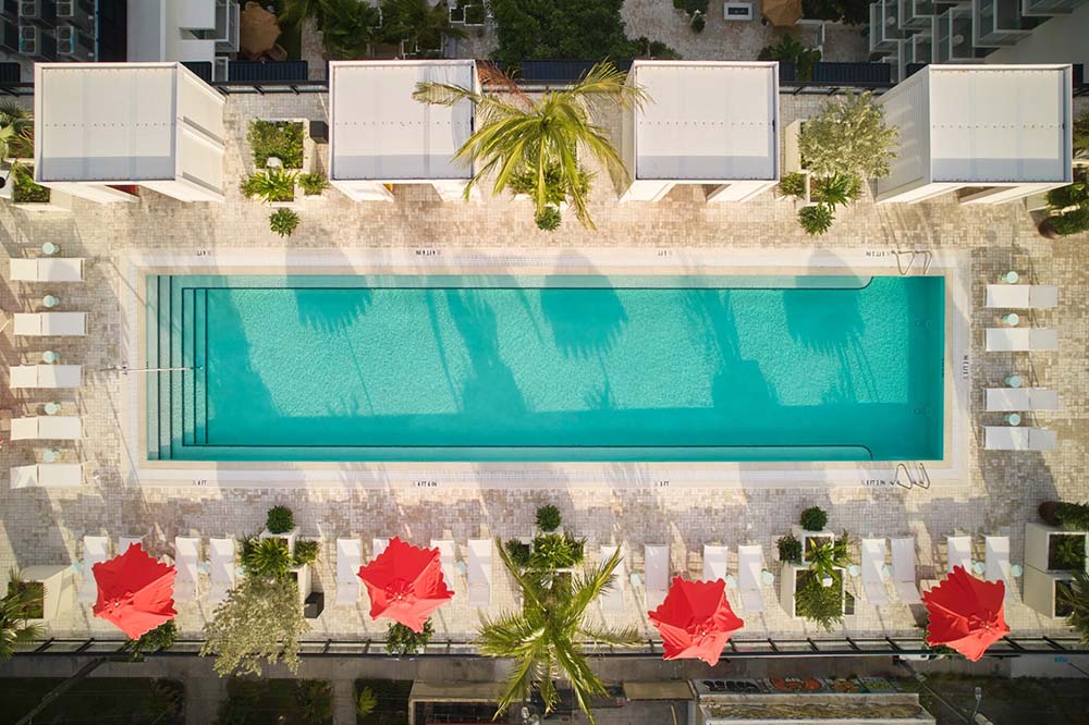 Arlo Hotel aerial view: resort cabanas along 76-foot-long heated rooftop pool, to delivery functional amenities for the hotel’s high-end clientele - By Azenco Outdoor.