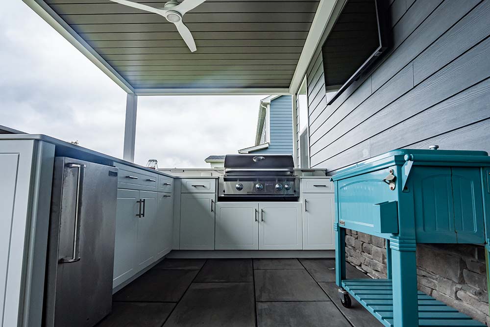 outdoor cooking station surrounded by a bar and covered with R-Blade louvered roof pergola - Azenco