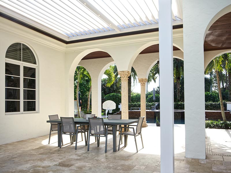White motorized pergola roof inserted in existing patio structure. Mediterranean home - Azenco