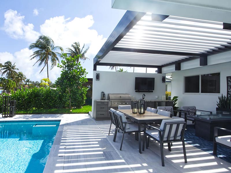Pool in Florida featuring a beautiful covered outdoor space with a pool, outdoor kitchen and lounging space - Azenco