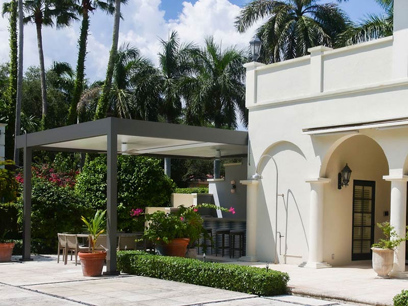 Side view of this stunning mediterranean patio enhanced with a modern aluminum pergola - model R-Shade by Azenco