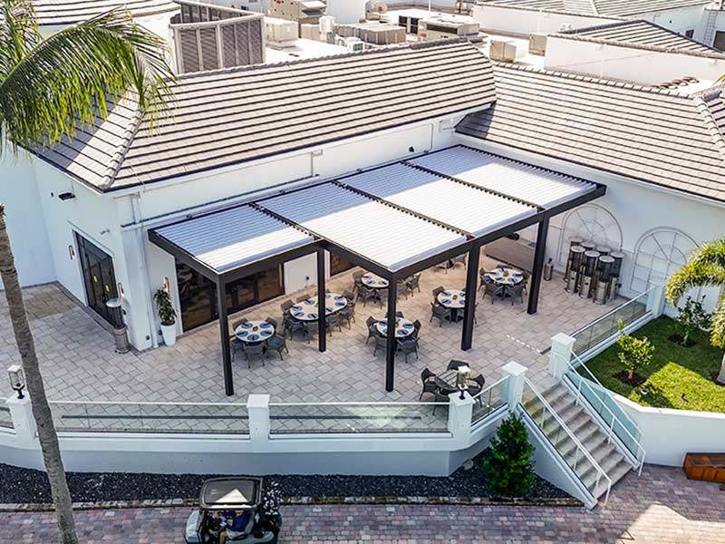 Global view of the Broken Sound Club terrace with recent pergola addition: Model R-Blade by Azenco Outdoor