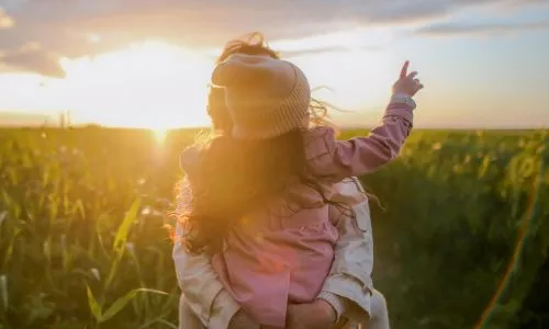 Image representing a mother and her daughter enjoying life outdoors at sunset.