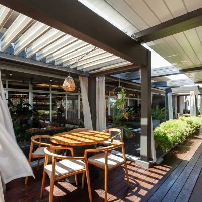 commercial shade structures with grey frame and white louvered roof for a restaurant terrace - Azenco Outdoor