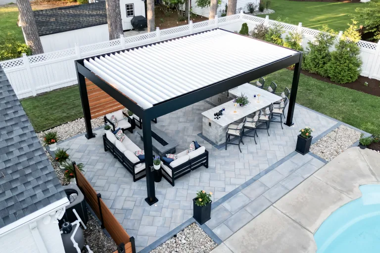 This aerial view shows an R-Blade pergola in a backyard. The pergola is surrounded by outdoor furniture, making it a great place to relax and enjoy the outdoors.