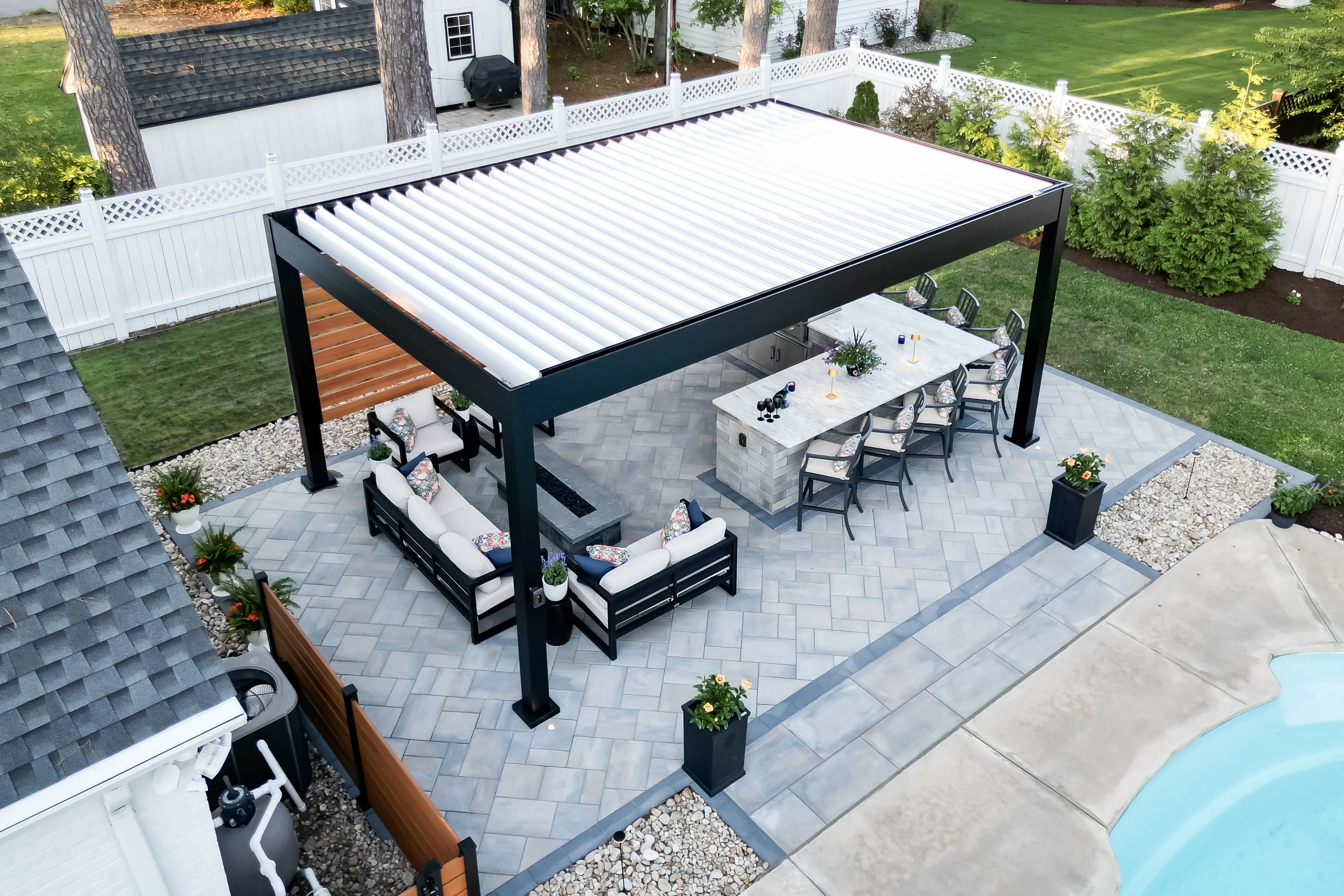 This aerial view shows an R-Blade pergola in a backyard. The pergola is surrounded by outdoor furniture, making it a great place to relax and enjoy the outdoors.