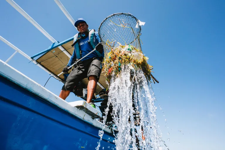 4ocean crew member picking up waste