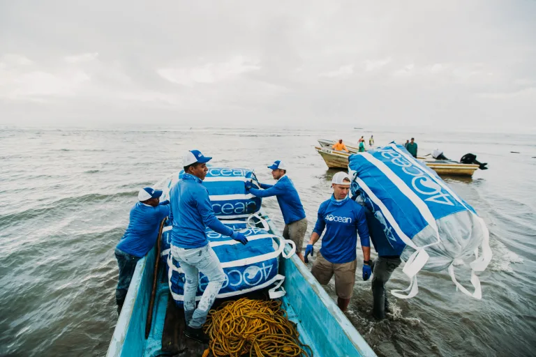 4ocean cleanup crew in the water picking up waste