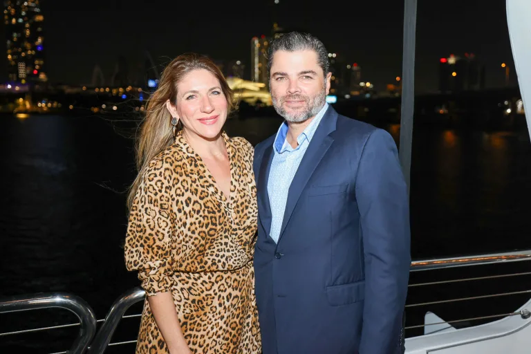 a man and woman standing together smiling at the camera