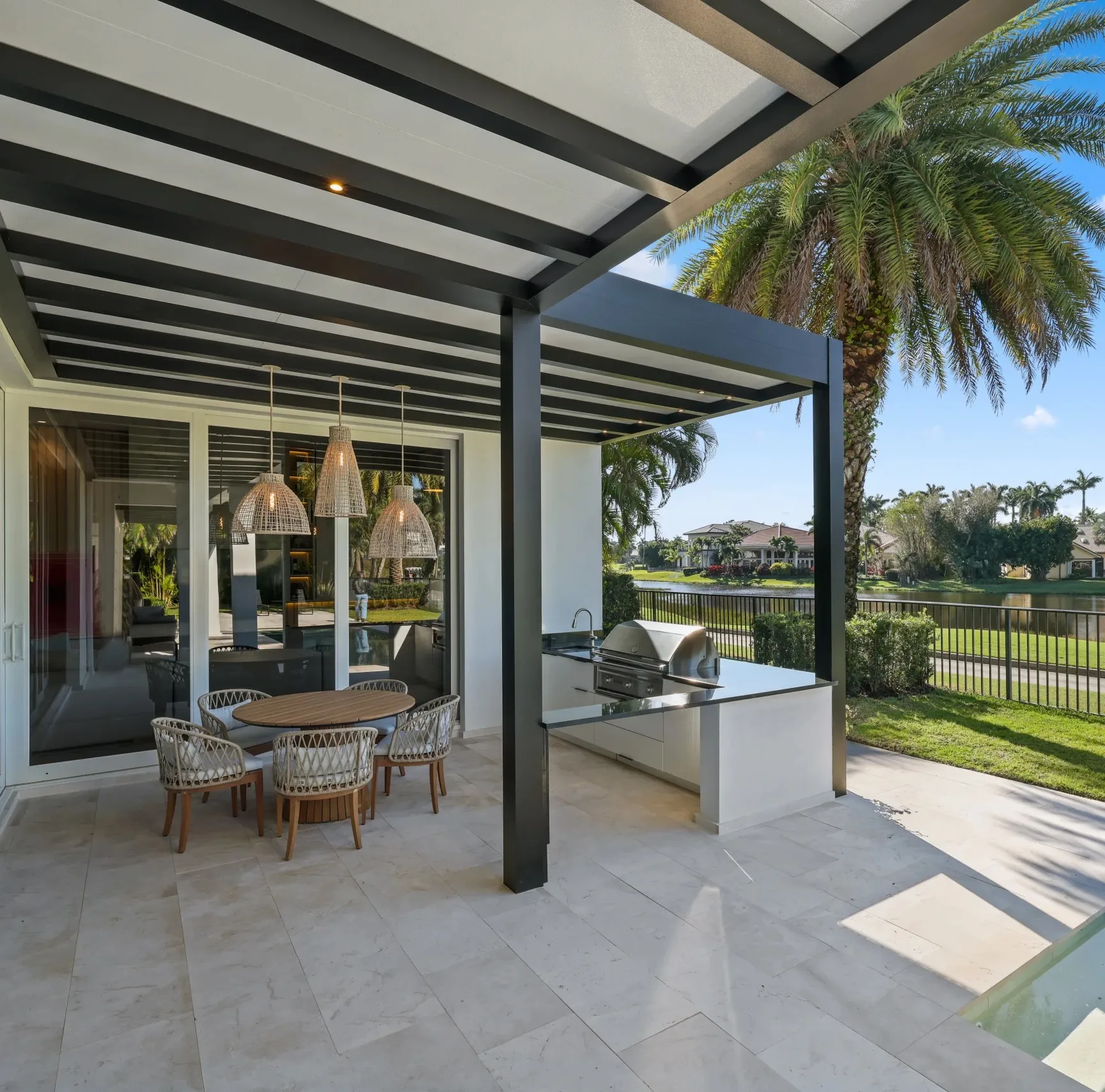 R-SHADE insulated patio cover with white roof panels over an outdoor kitchen and dining area
