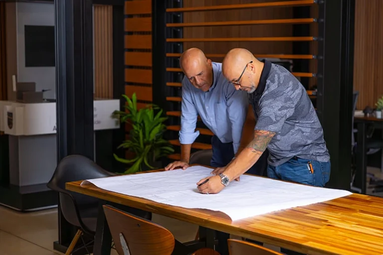 Architects reviewing pergola plans at a drafting table