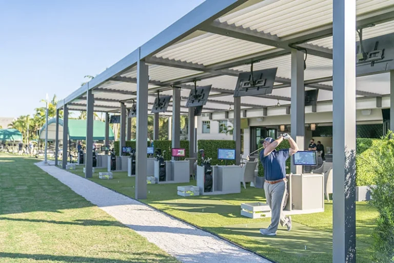 Commercial louvered pergola shading the hitting bays of a golf venue