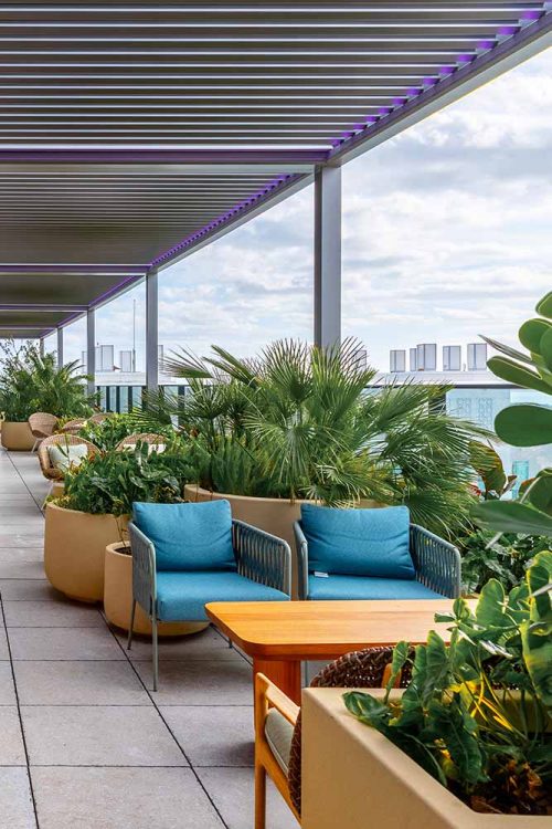 Hotel rooftop lounge space with automated pergola by Azenco