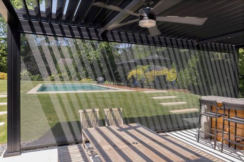 Black louvered pergola with screens