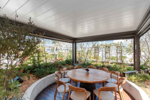 Black and whte aluminum pergola for restaurant rooftop terrace. The louvers are shown sealed and closed for element protection: R-BLAD Eby Azenco Outdoor