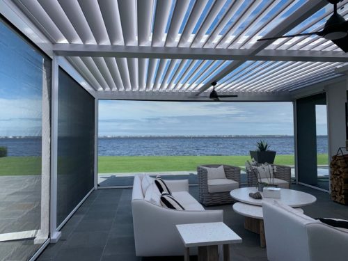 Covered patio with louvered pergola and automated insect screens - hurricane zone