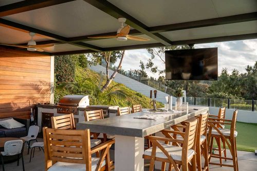 Outdoor kitchen and dining table with insulated perogla roof. R-SHADE by Azenco