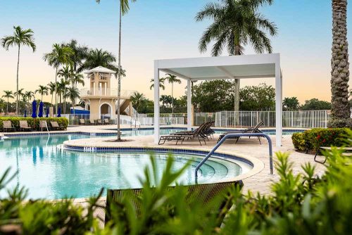 Covered lounging area at a community pool - R-SHADE pergola by Azenco
